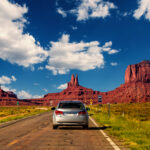 Monument Valley, United States – September 10, 2015: Highway in Monument Valley, Utah / Arizona, USA – Picture with road and cars driving towards the hills. Photo made during a road trip throughout the western states.