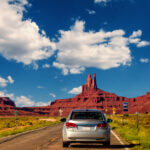 Monument Valley, United States – September 10, 2015: Highway in Monument Valley, Utah / Arizona, USA – Picture with road and cars driving towards the hills. Photo made during a road trip throughout the western states.
