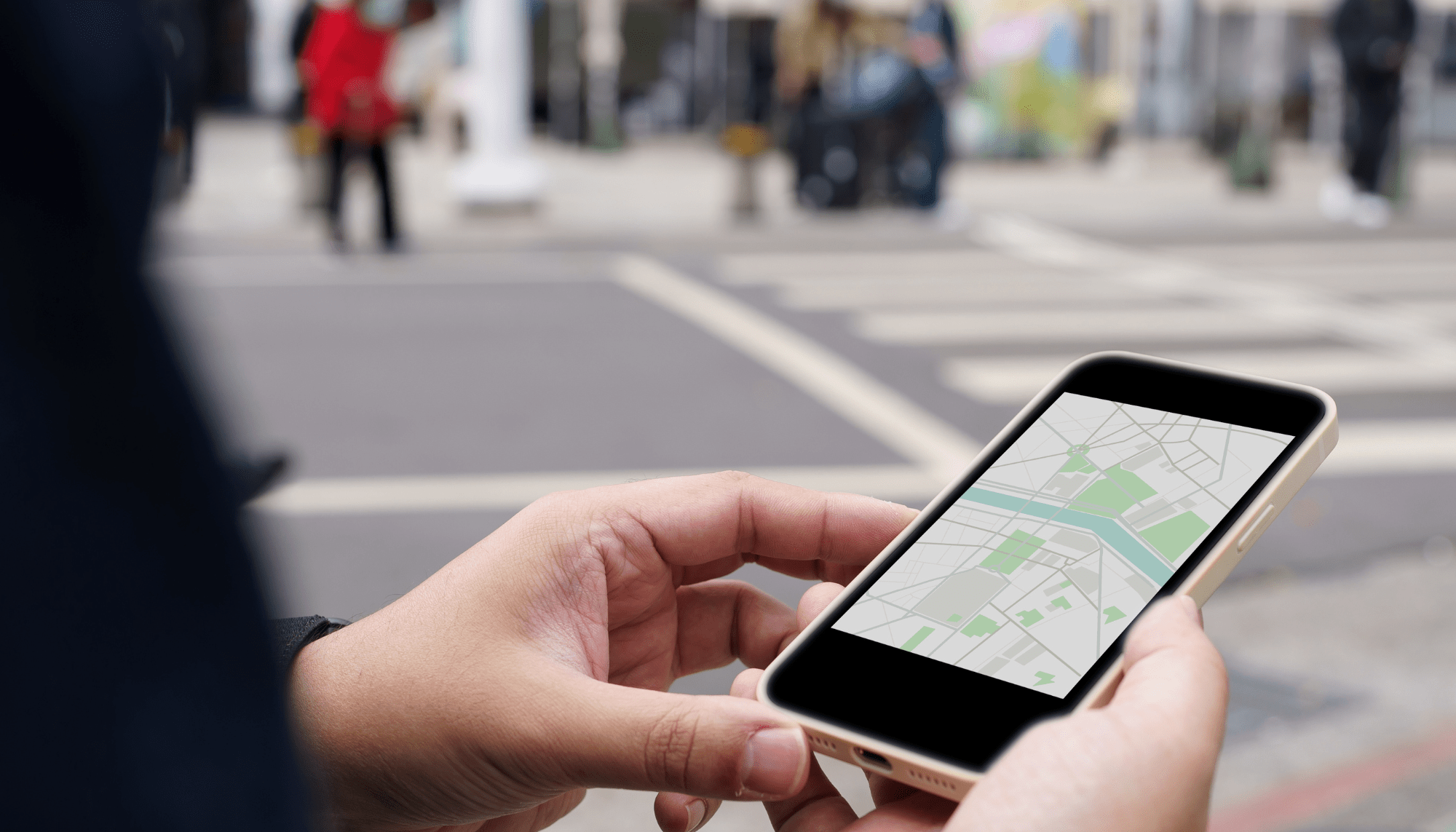person standing on street corner looking at phone with map app open; only hands are visible