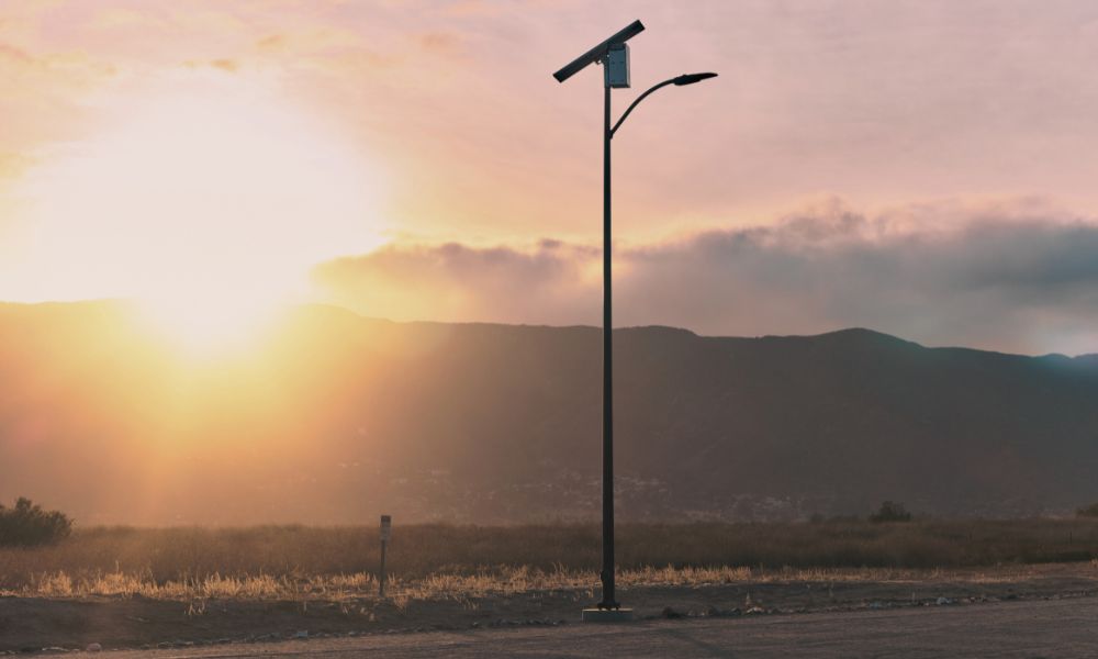 single solar light with sun setting behind a mountain